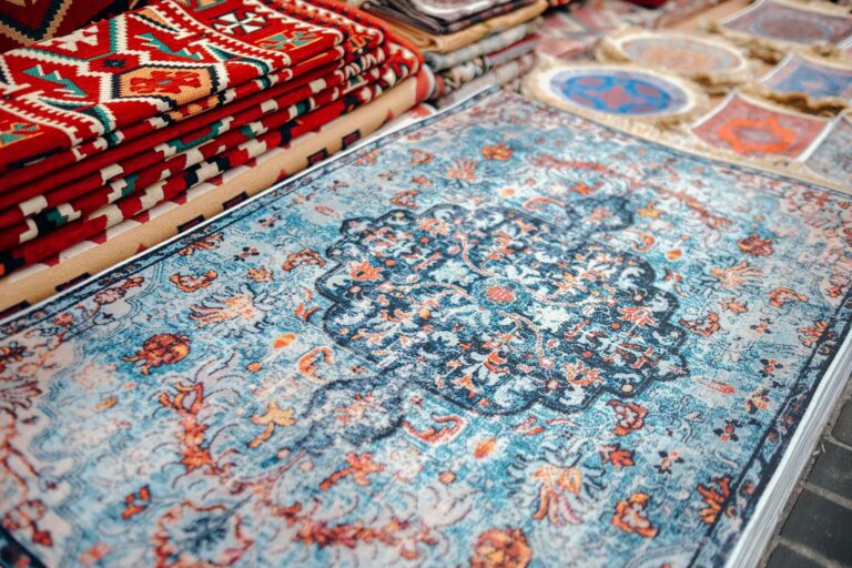 A collection of traditional handmade carpets with vibrant patterns on display.