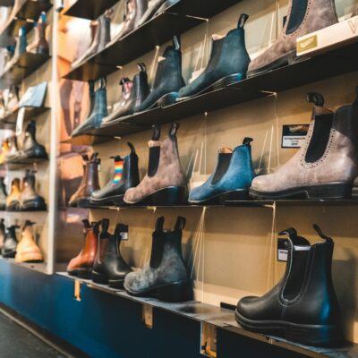 Elegant leather boots on display shelves in a fashion retail store.