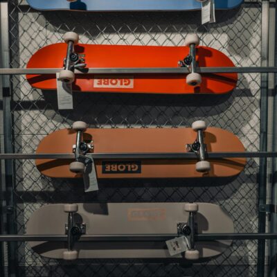 Photo by Çağın KARGI Vibrant skateboard collection displayed vertically in a modern skateshop setting.